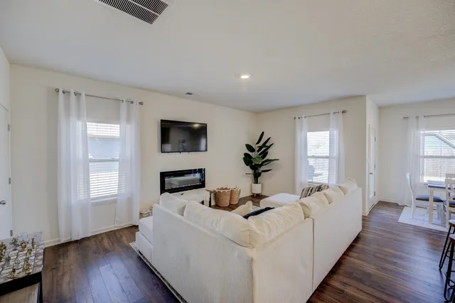 a living room with furniture a flat screen tv and a window