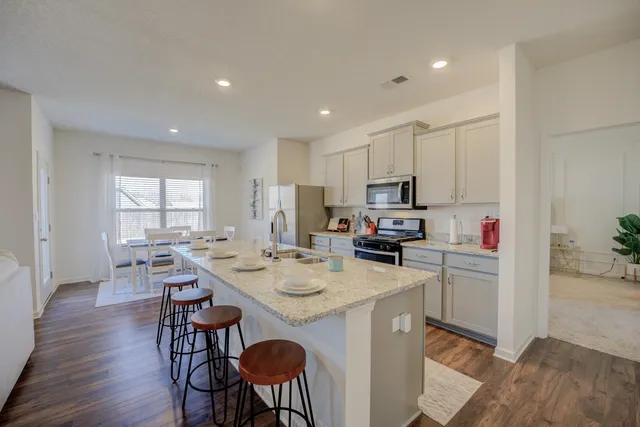 a kitchen that has a lot of cabinets a sink and appliances in it
