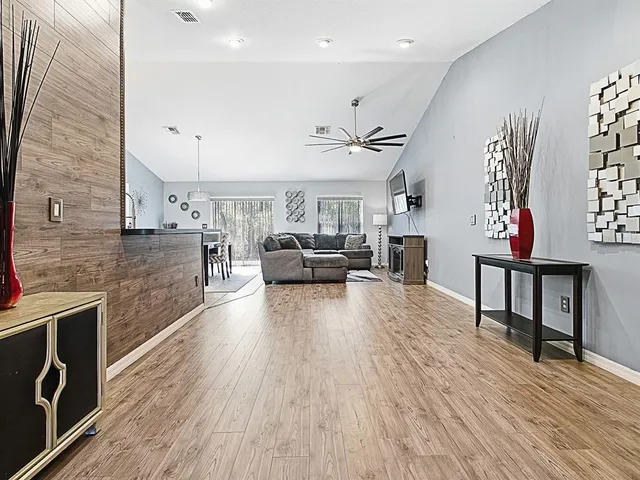 a living room with furniture and a wooden floor