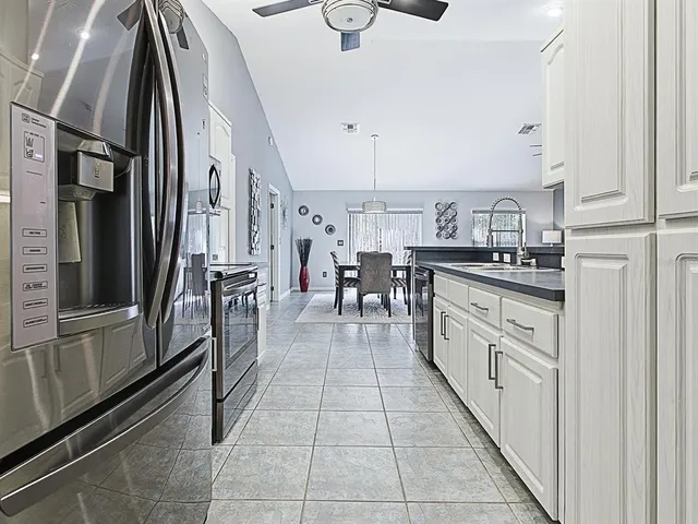 a large kitchen with stainless steel appliances a refrigerator and a stove