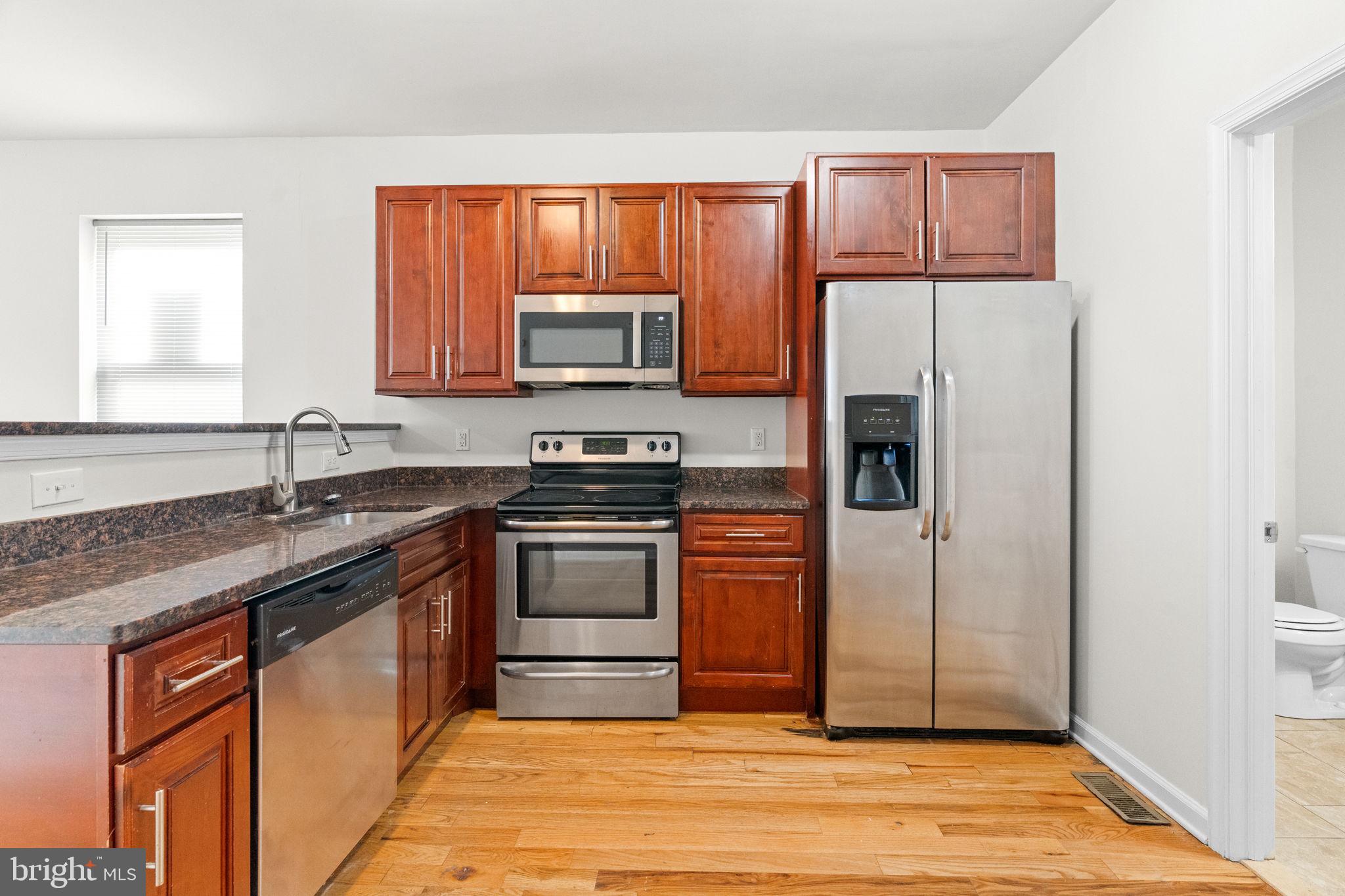 2106 North 17th Street Philadelphia, PA 19121 - Photo 15 of 84 a kitchen with stainless steel appliances granite countertop a refrigerator stove and sink