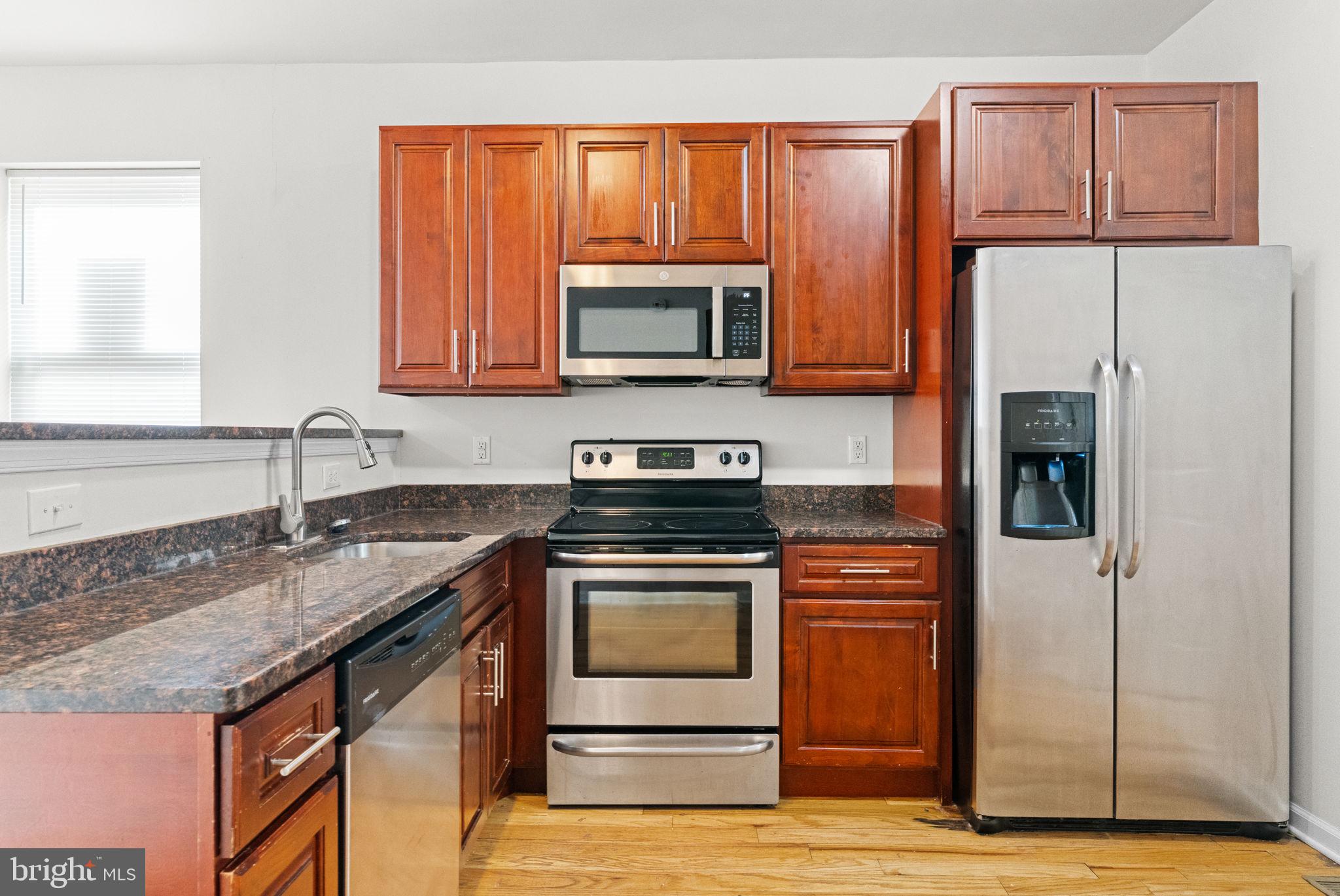 2106 North 17th Street Philadelphia, PA 19121 - Photo 16 of 84 a kitchen with granite countertop a stove top oven microwave and refrigerator