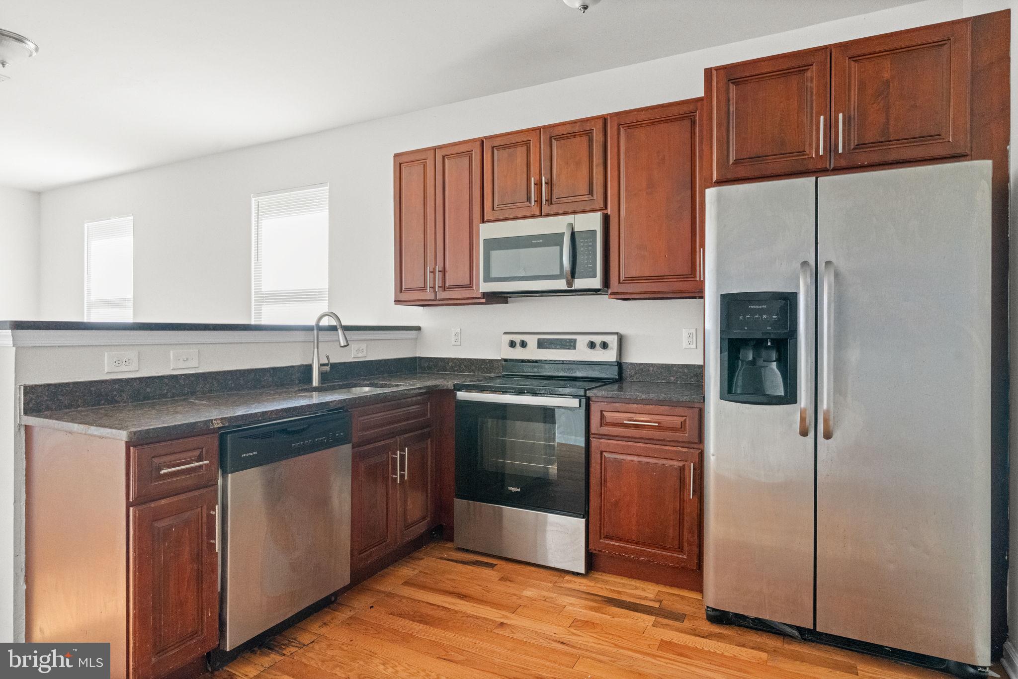 2106 North 17th Street Philadelphia, PA 19121 - Photo 48 of 84 a kitchen with stainless steel appliances granite countertop a refrigerator a stove a sink and a microwave