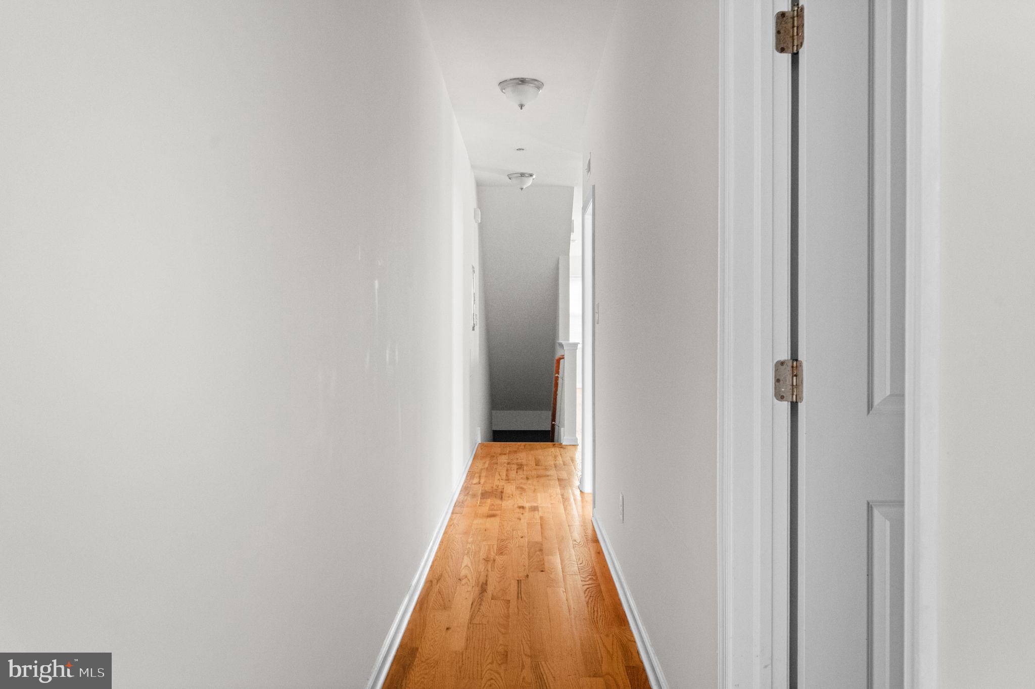 2106 North 17th Street Philadelphia, PA 19121 - Photo 59 of 84 a view of a hallway with wooden floor and a bathroom