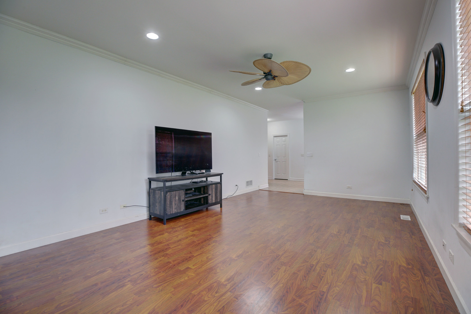 863 Oak Ridge Boulevard Elgin, IL 60120 - Photo 20 of 46 a view of a livingroom with a flat screen tv wooden floor and a ceiling fan