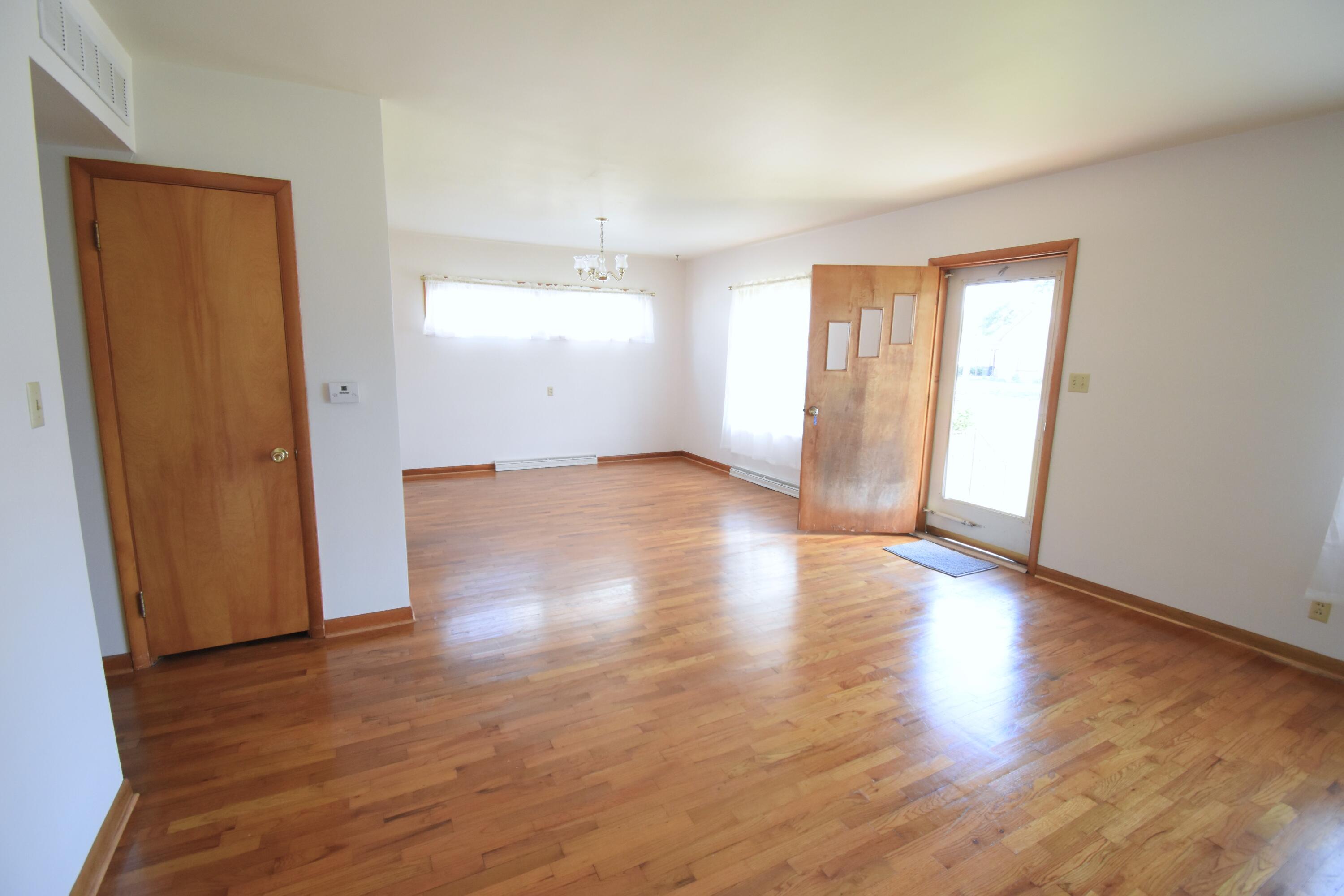 328 South Weston Street Rensselaer, IN 47978 - Photo 3 of 39 an empty room with wooden floor and windows