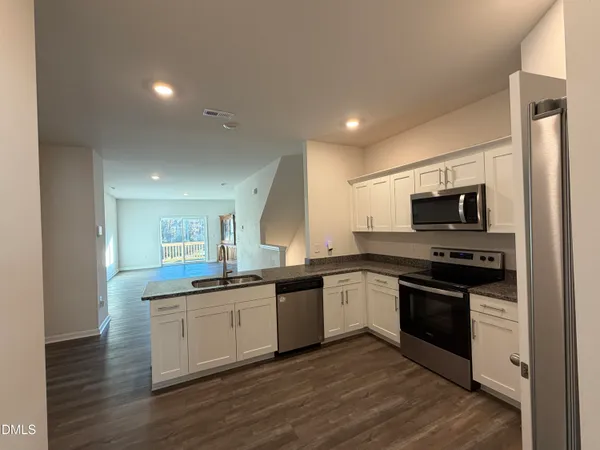 a kitchen with stainless steel appliances granite countertop a sink and stove top oven