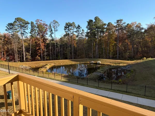 a view of swimming pool with outdoor seating and trees in the background