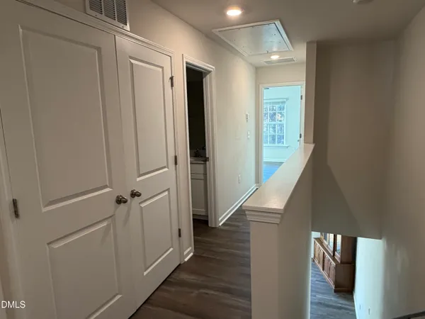 a view of a hallway with wooden floor and staircase