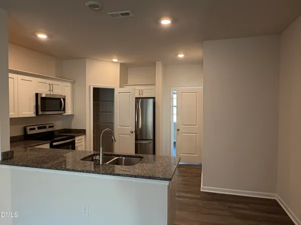 a view of a kitchen with a sink and a refrigerator