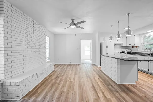 a kitchen with kitchen island white cabinets stainless steel appliances a sink and a stove