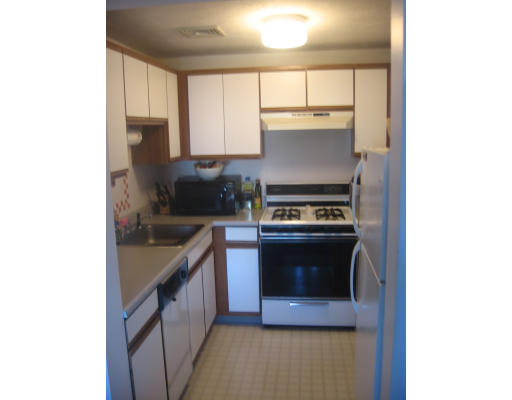 360 Littleton Road, Unit A11 Chelmsford, MA 01824 - Photo 2 of 8 a kitchen with stainless steel appliances granite countertop a stove a sink and a microwave