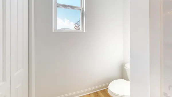 a white toilet sitting next to a white vanity
