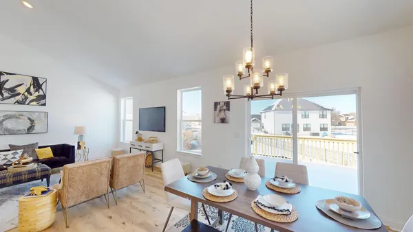 a view of a dining room with furniture a chandelier and wooden floor