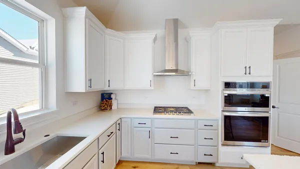 a kitchen with cabinets appliances a sink and a window