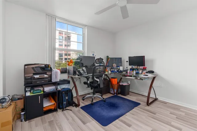 a view of a workspace with furniture and a window