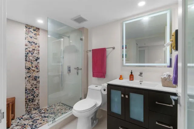 a bathroom with a sink toilet vanity and shower