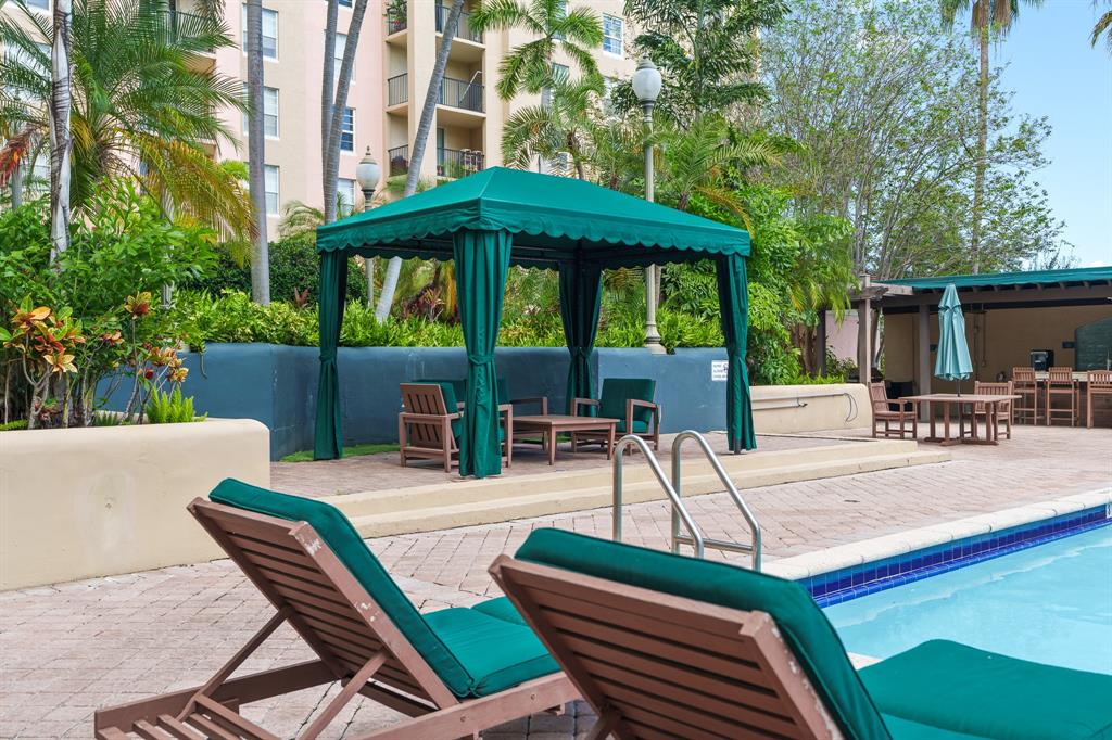 520 Southeast 5th Avenue, Unit 2209 Fort Lauderdale, FL 33301 - Photo 31 of 47 a view of patio with a dining table and chairs under an umbrella with a small yard