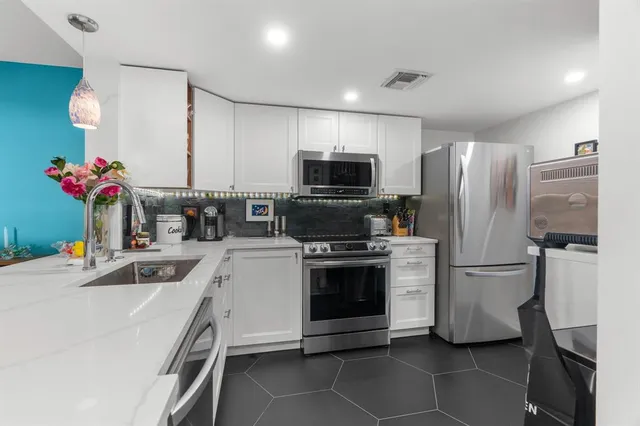 a kitchen that has a refrigerator and a sink