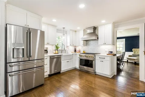 a kitchen with stainless steel appliances white cabinets and a refrigerator