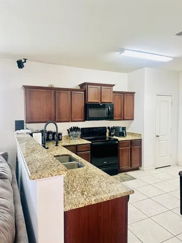 a kitchen with stainless steel appliances granite countertop a sink stove and microwave