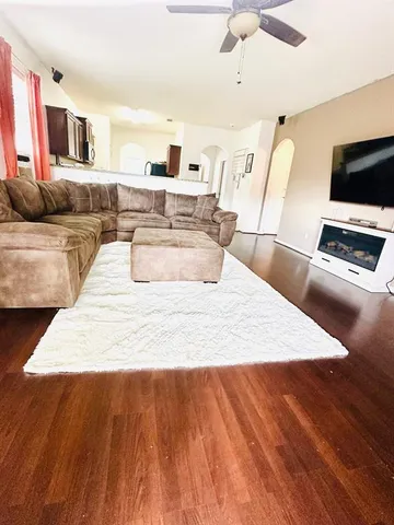 a large bedroom with wooden floor and flat screen tv