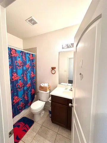 a bathroom with a sink a toilet and shower curtain