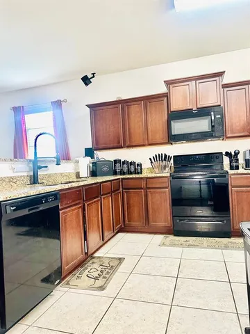 a kitchen with stainless steel appliances kitchen island granite countertop a stove a sink and a microwave