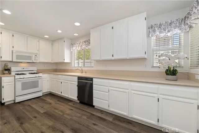a kitchen with wooden floors and white walls