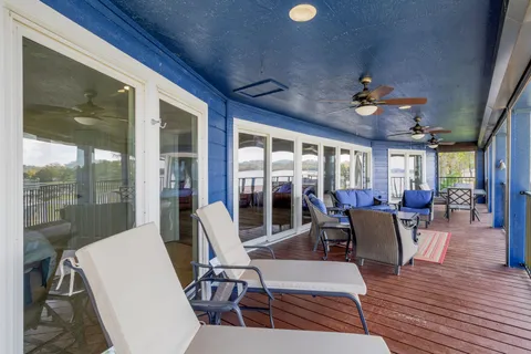 a balcony with wooden floor stairs and furniture