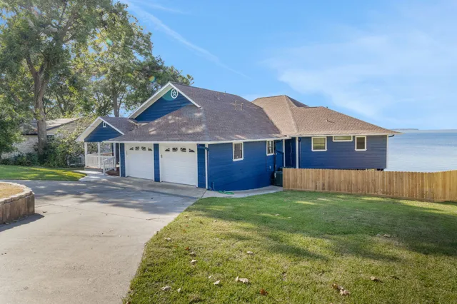 a living room with couches a kitchen counter space and a flat screen tv