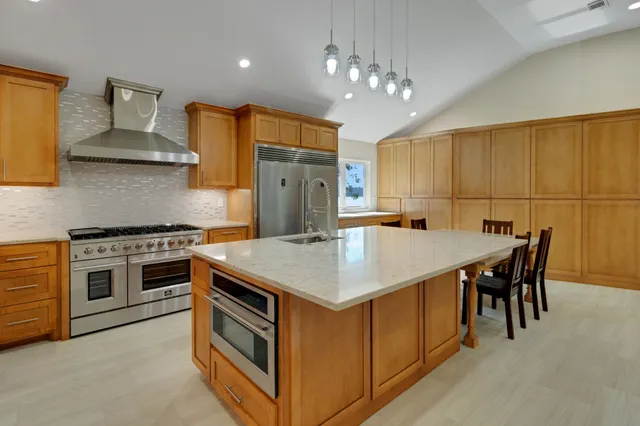 a kitchen with stainless steel appliances granite countertop a sink stove and refrigerator