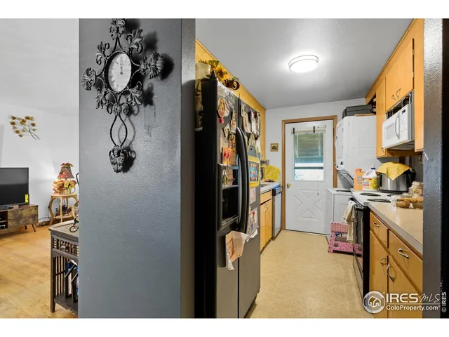 a view of dresser and kitchen with wooden floor