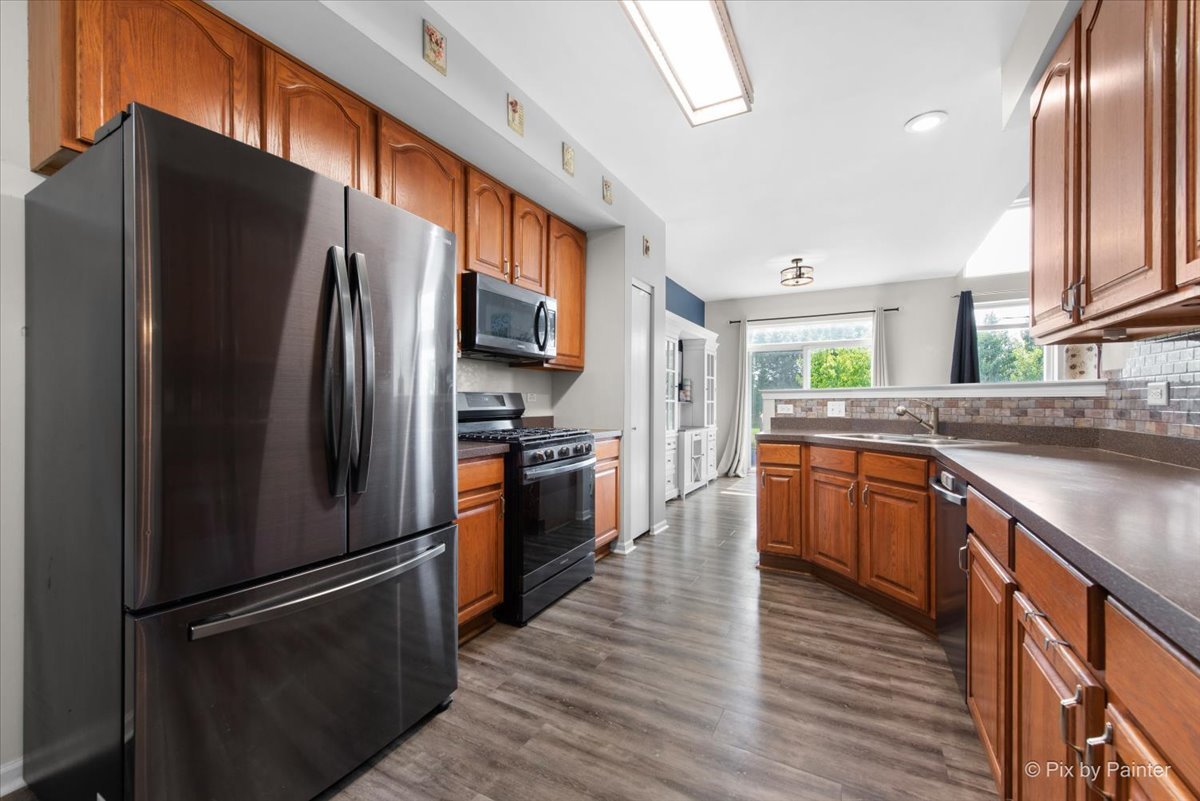 1033 Key Largo Drive Romeoville, IL 60446 - Photo 6 of 30 a kitchen with stainless steel appliances granite countertop a refrigerator stove and wooden floor