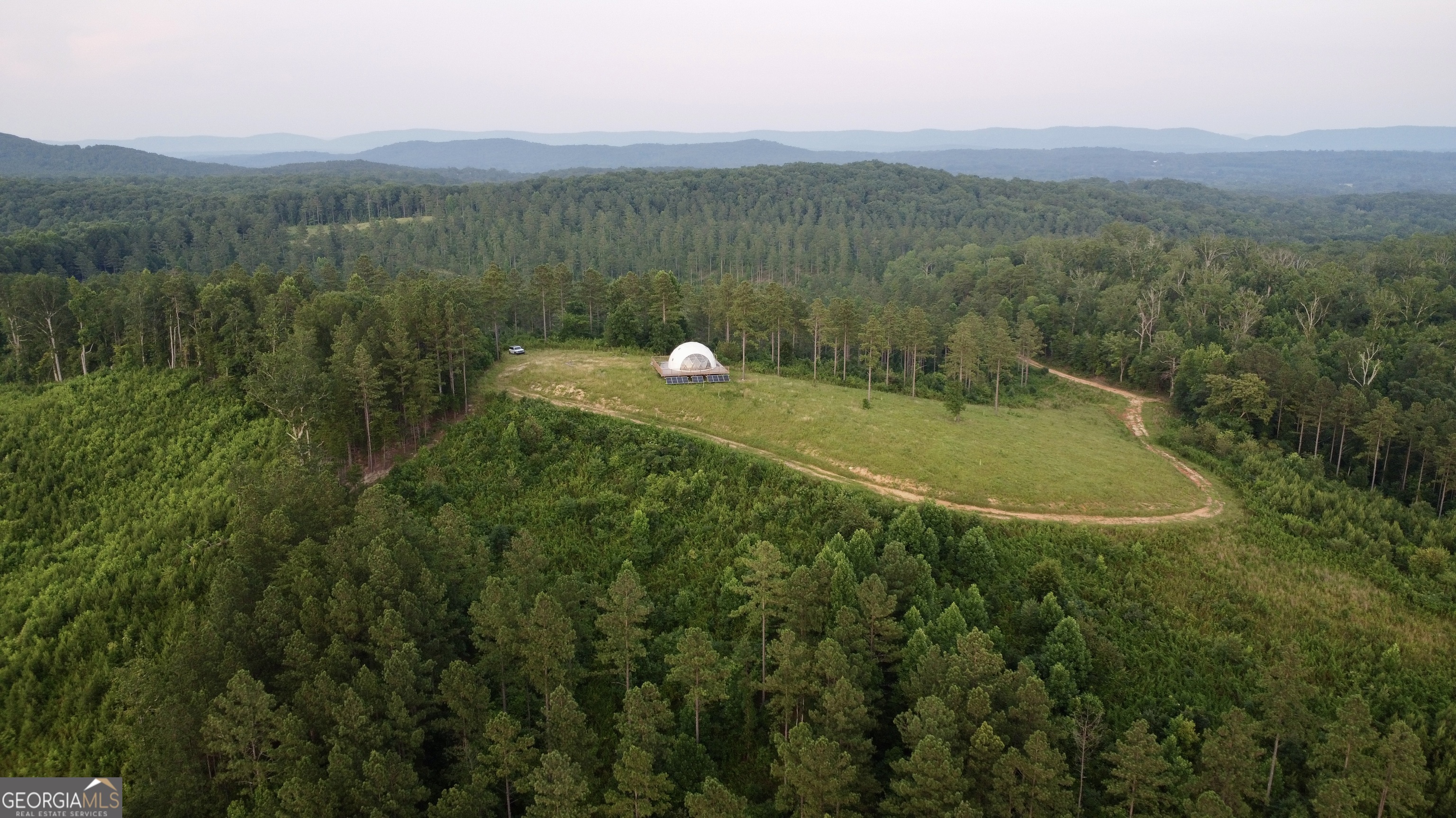 a view of a green field with mountains in the background