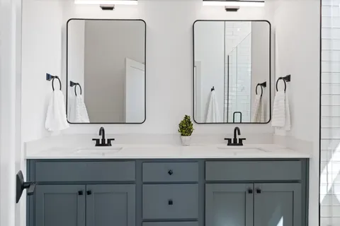 a bathroom with double vanity sinks and a mirror