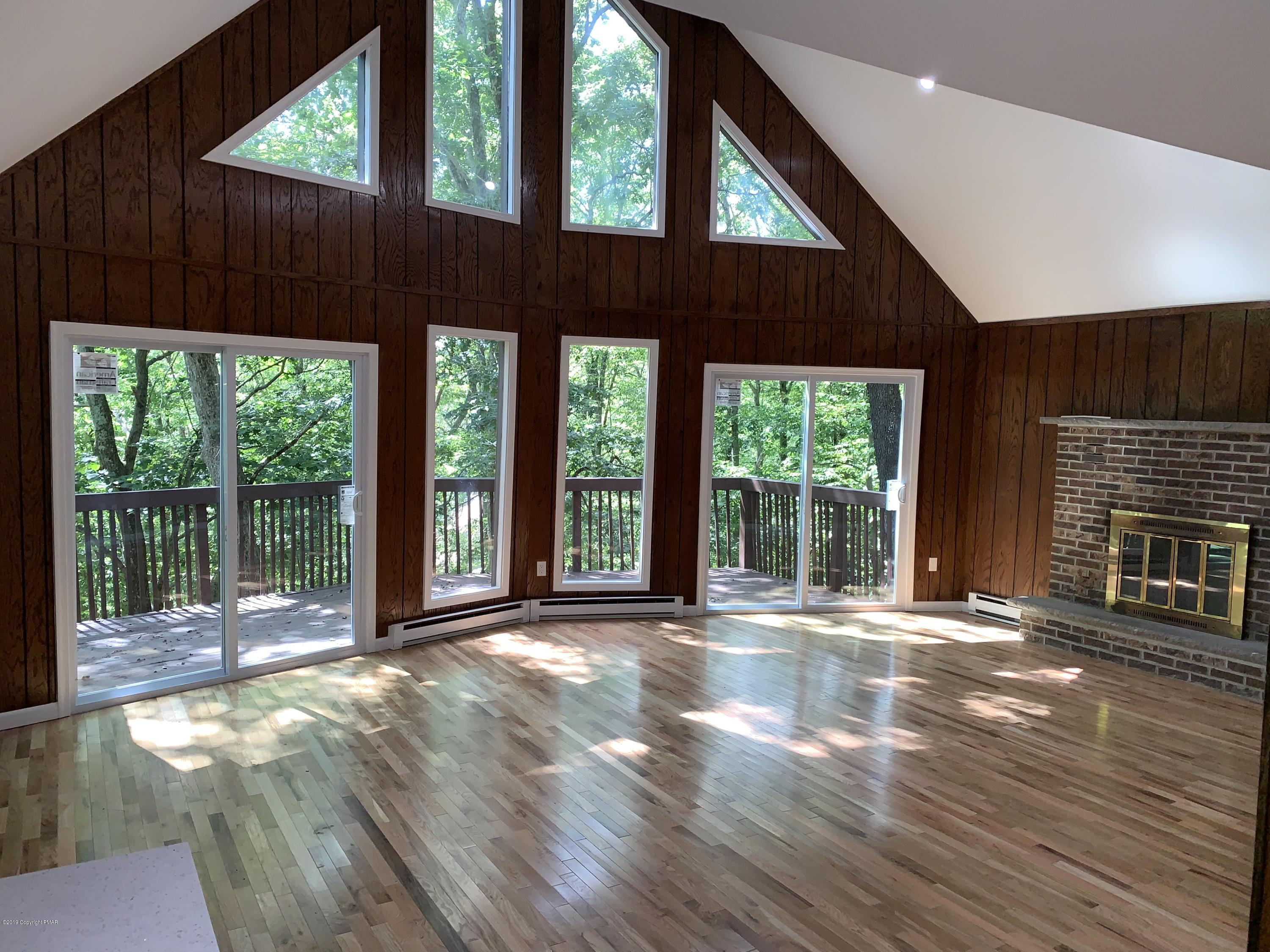 125 Edinburgh Road Bushkill, PA 18324 - Photo 2 of 19 a view of an room with wooden floor and a fireplace