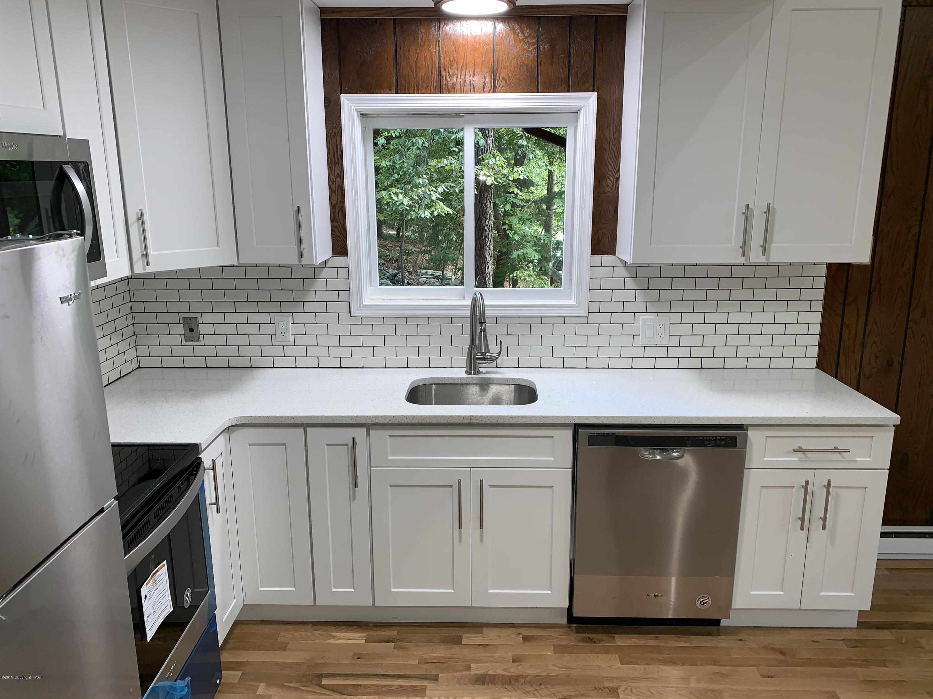 125 Edinburgh Road Bushkill, PA 18324 - Photo 6 of 19 a kitchen with stainless steel appliances granite countertop a sink a stove a microwave a counter space and cabinets