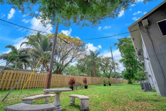 a view of a chair and table in backyard of the house