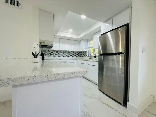 a kitchen with a refrigerator and a sink