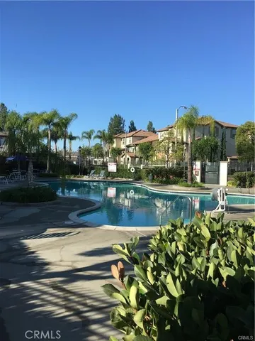 a front view of a house with a yard and palm trees