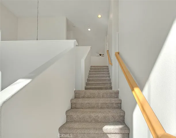 an empty room with wooden floor chandelier fan and windows