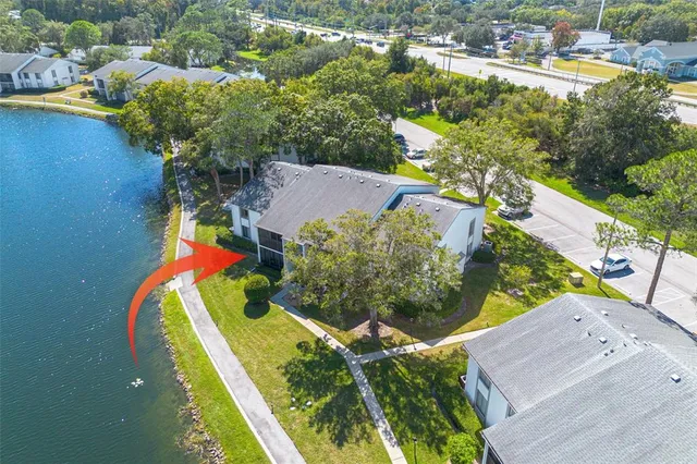 an aerial view of a house with a yard and lake view