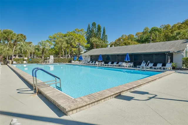 a view of swimming pool with outdoor seating and a big yard