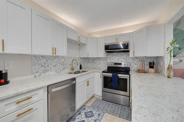 a kitchen with stainless steel appliances white cabinets and a sink