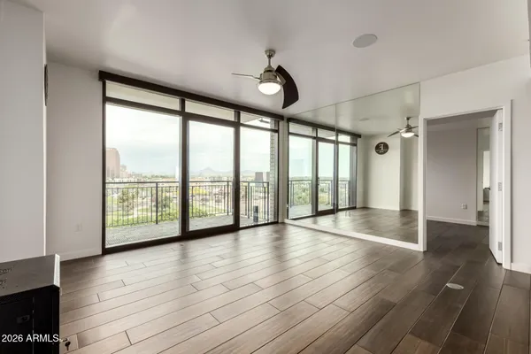 an empty room with wooden floor and windows