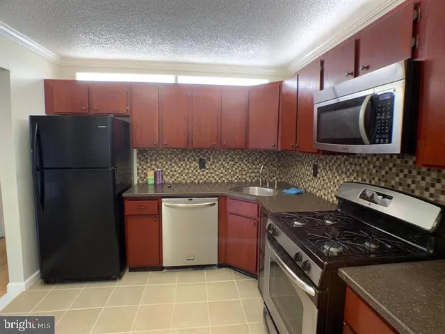 a kitchen with stainless steel appliances granite countertop a refrigerator stove a sink and dishwasher