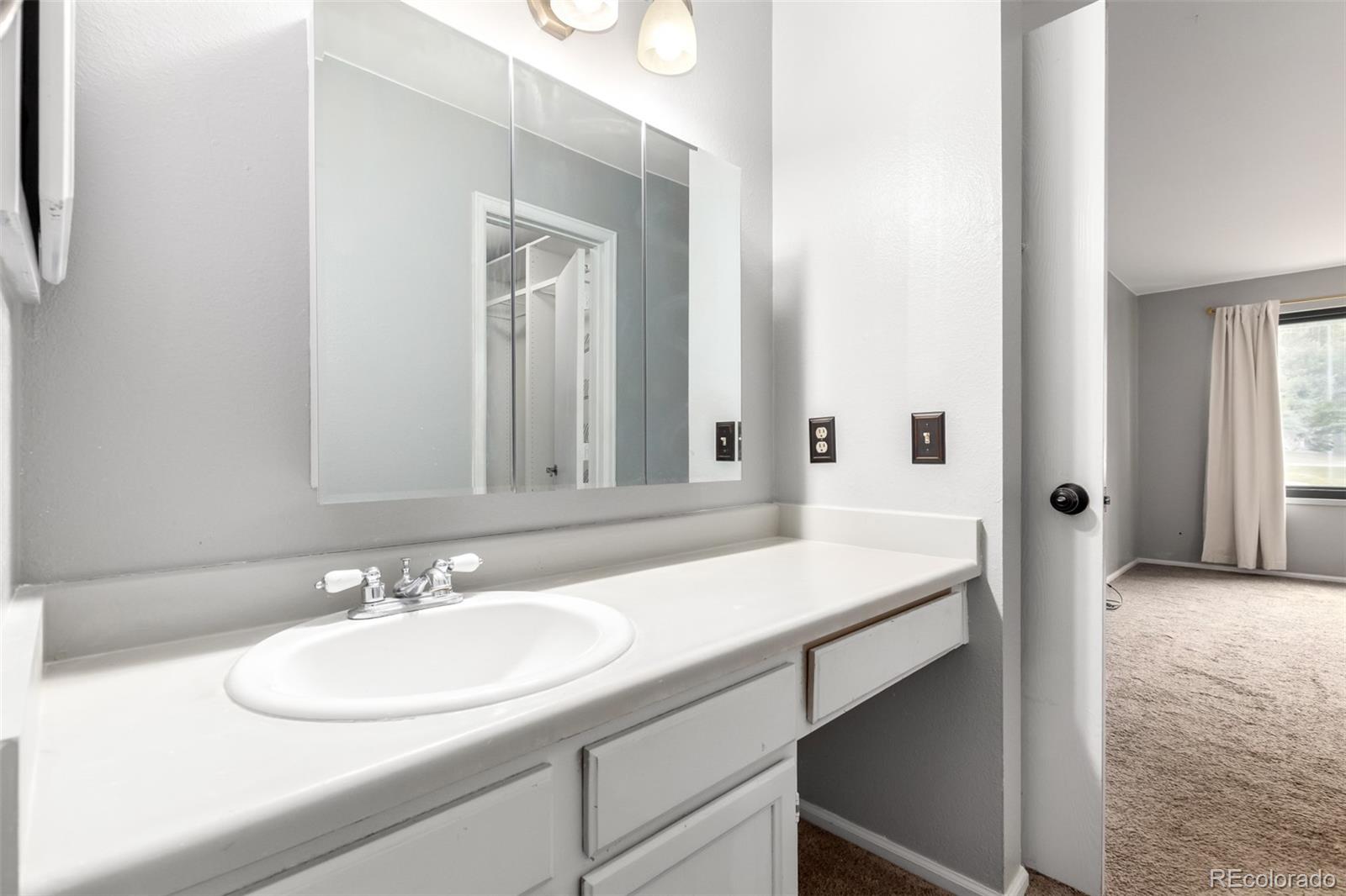 401 South Kalispell Way, Unit 104 Aurora, CO 80017 - Photo 14 of 29 a bathroom with a sink and a mirror