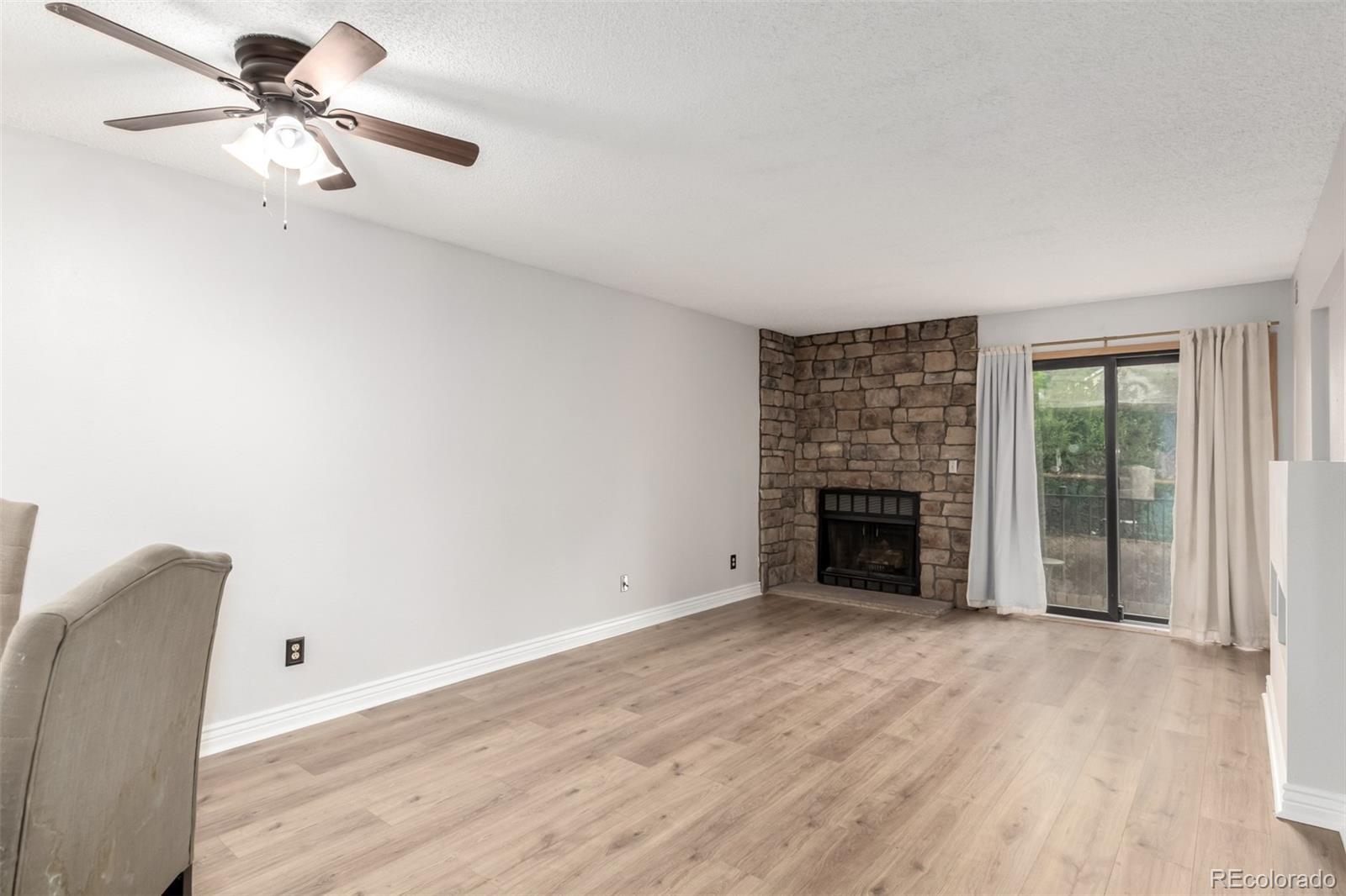 401 South Kalispell Way, Unit 104 Aurora, CO 80017 - Photo 4 of 29 a view of a livingroom with a fireplace a ceiling fan and windows
