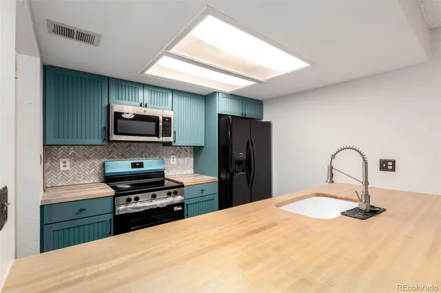 a kitchen with a refrigerator and a stove top oven